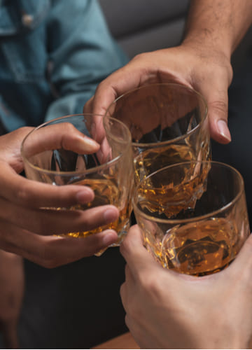  Лечение алкоголизма на дому: мужчины держат стаканы с алкоголем